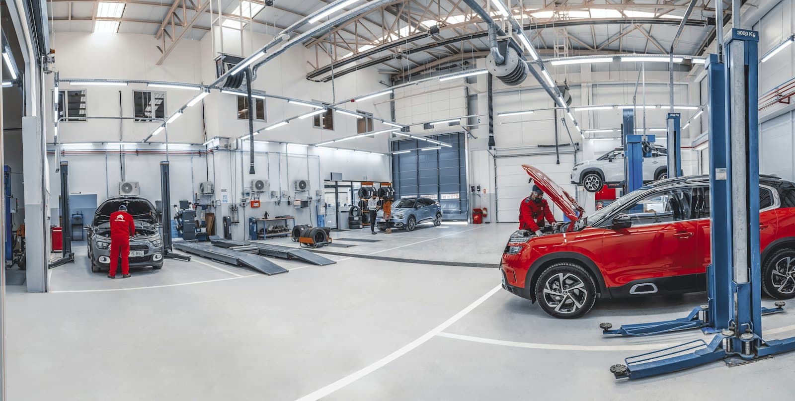 Mechanics working on cars in a bright repair workshop